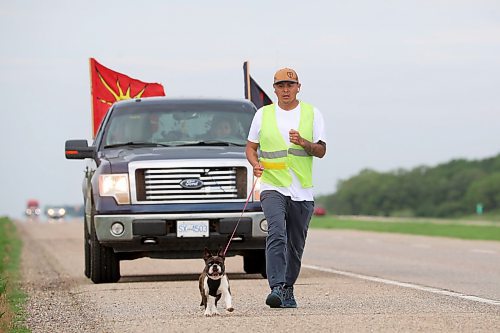 29052023
Cameron West jogs east along the Trans Canada Highway towards Carberry with his french bulldog Gretchen while his wife Charity takes her turn driving the support vehicle on Monday morning. The couple are walking across Canada to draw attention to missing and murdered Indigenous people. They began their first leg of the walk in Siksika Nation in southern Alberta and are walking to St. John's, Nfld. From there they will begin their second leg in Prince Rupert , BC, and walk the Highway of Tears, Highway 16, where several Indigenous Canadians have gone missing, home to Prince George. They average approximately 40-50 KM's a day. 
(Tim Smith/The Brandon Sun)