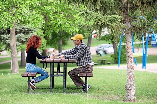 30052023
Ruth Birhane and Anmol Singh play Uno at a picnic table in Rideau Park on a hot Tuesday evening. 
(Tim Smith/The Brandon Sun)