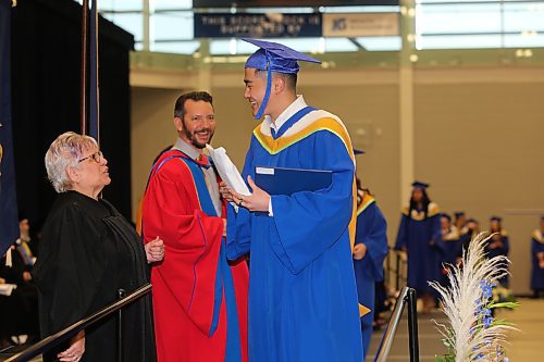 Jeffrey Peijia Li grabs his Bachelor of Science degree from Brandon University officials during Thursday morning's convocation ceremony at Healthy Living Centre. (Kyle Darbyson/The Brandon Sun)
