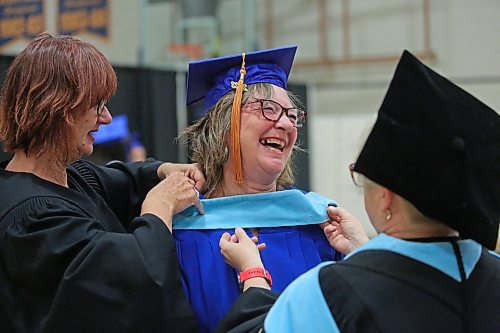 Brandon University education student Kathleen Anne Slashinsky laughs during a light moment while Karen Skinner, right, and Joan Garbutt, left, with student services help with part of her graduation gown before convocation on Thursday afternoon at the Healthy Living Centre. Slashinsky received a Master of Education degree from Brandon University. (Matt Goerzen/The Brandon Sun)