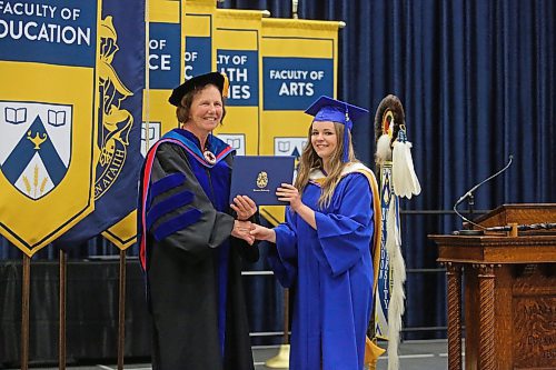 Bachelor of Education graduate Abby Madison Jago holds her degree while posing with University Registrar Andrea McDaniel during Thursday afternoon's convocation ceremony at the Healthy Living Centre. Ms Jago earned a gold medal this year, which is awarded for the highest standing in the degree program. (Matt Goerzen/The Brandon Sun)