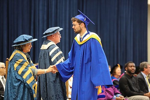 Matthew Frechette shakes hands with Brandon University Chancellor Mary Jane McCallum during Friday morning's convocation ceremony, where he received a Bachelor of Science in Psychiatric Nursing degree. (Kyle Darbyson/The Brandon Sun)