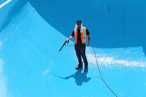 Dallas Hully with the City of Brandon Parks and Recreation Services gives Kinsmen Pool in Brandon a spray wash on Friday, in preparation of its opening day, June 16th. (Michele McDougall/The Brandon Sun)