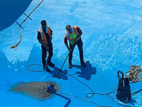 Dallas Hully and Dylan Kauenhofen with the City of Brandon Parks and Recreation Services give Kinsmen Pool in Brandon a spray wash and sweep on Friday, in preparation of its opening day, June 16th. (Michele McDougall/The Brandon Sun)