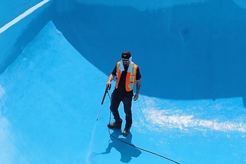 Dallas Hully with the City of Brandon Parks and Recreation Services gives Kinsmen Pool in Brandon a spray wash on Friday, in preparation of its opening day June 15. (Michele McDougall/The Brandon Sun)