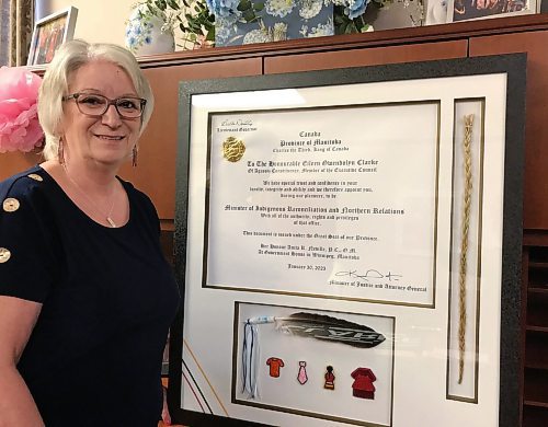 CAROL SANDERS / WINNIPEG FREE PRESS

Clarke with &#x201c;a precious reminder of what&#x2019;s been done and a reason to be proud&#x201d; &#x2013; she had the document proclaiming her the minister framed with an eagle feather, sweet grass and pins given to her by Indigenous leaders and community members. 

 