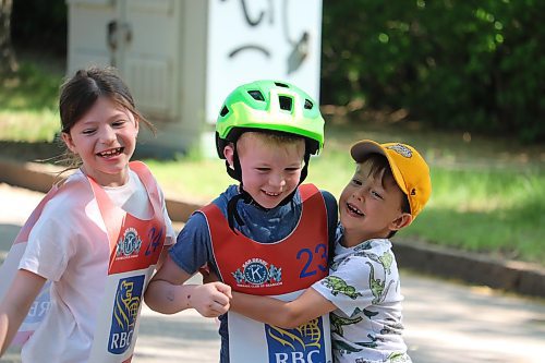 Lukas LeBlanc receives a congratulatory hug from his sister Peyton and friend Boston Potter after winning an important race during Saturday’s Kiwanis Kar Derby. (Kyle Darbyson/The Brandon Sun)