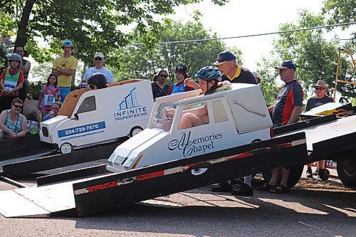 A Kiwanis Kar Derby pit crew feverishly works to repair a soap box car before the next race is called on Saturday morning. (Kyle Darbyson/The Brandon Sun)