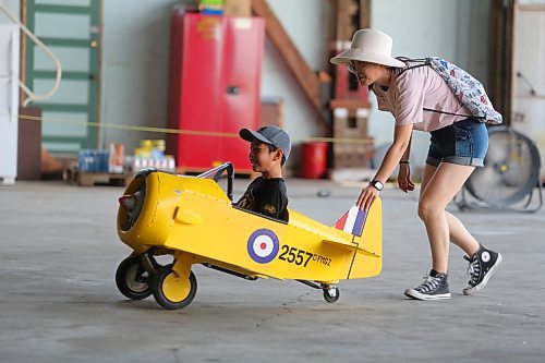 Hong Wang pushes her son Rey Liu in one of the Commonwealth Air Training Plan Museum’s toy aircrafts during the facility’s grand reopening on Sunday. (Kyle Darbyson/The Brandon Sun)