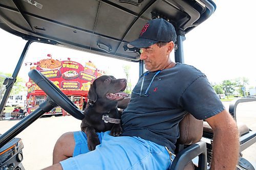 Rick Ukmar, owner of Rick's Concessions, pats his son's dog Sako, who turned one year old on Monday afternoon. While setting up for the Manitoba Summer Fair, Ukmar has been keeping Sako in an air-conditioned trailer on Monday and throughout the weekend, as temperatures in Brandon hit more than 32 C for several consecutive days. (Photos by Matt Goerzen/The Brandon Sun)