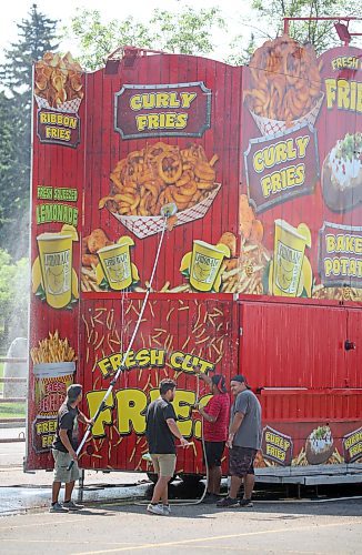 Workers wash the side of a french fry booth at the Keystone Centre parking lot on Monday morning, in anticipation of the opening of the Brandon Summer Fair on Wednesday afternoon. (Matt Goerzen/The Brandon Sun)