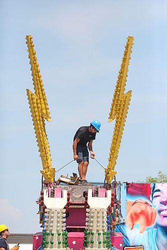 An employee of North American Midway stands between lightning bolts while working on one of the many midway rides being readied for the Manitoba Summer Fair, which opens on Wednesday afternoon. (Matt Goerzen/The Brandon Sun)