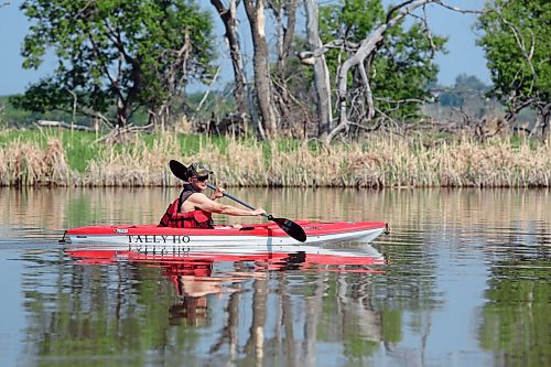 Ron Fontaine in his kayak 'Tally Ho' takes a morning paddle on the smooth-as-glass Assiniboine River near Dinsdale Park on Tuesday. (Michele McDougall/The Brandon Sun)