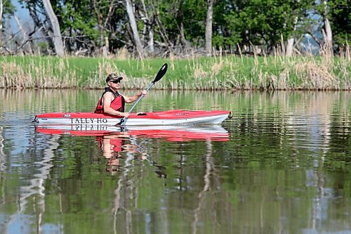 Ron Fontaine in his kayak 'Tally Ho' takes a morning paddle on the smooth-as-glass Assiniboine River near Dinsdale Park on Tuesday. (Michele McDougall/The Brandon Sun)