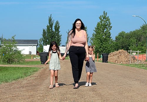 Taryn Stinson-Tuttle walks with two of her five children — Tyler, 4, (from left) and Truly, 3 — in Chater on Tuesday as they prepare for this month's Walk to End ALS in honour of Taryn's father, Craig Stinson. (Michele McDougall/The Brandon Sun) 