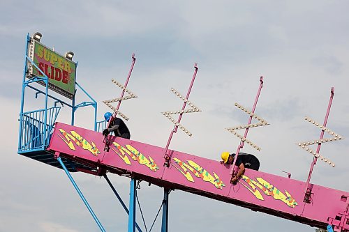 Workers set up rides for the Manitoba Summer Fair midway at the Keystone Centre in Brandon on Tuesday. The Summer Fair opens today. (Tim Smith/The Brandon Sun)