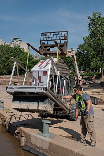 Mike Thiessen / Winnipeg Free Press Li Pei Gen of Seaco Marine guiding the ramp into place at The Forks Historic Port. 230606 &#x2013; Tuesday, June 6, 2023