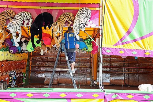 06062023
Jared McLeod hangs stuffed animals at one of the midway games during set-up for the Manitoba Summer Fair at the Keystone Centre in Brandon on Tuesday. The Fair opens today.  (Tim Smith/The Brandon Sun)