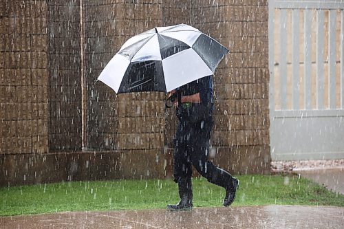 06062023
A pedestrian walks through pouring rain during a brief but heavy shower on a scorching hot Tuesday afternoon. (Tim Smith/The Brandon Sun)