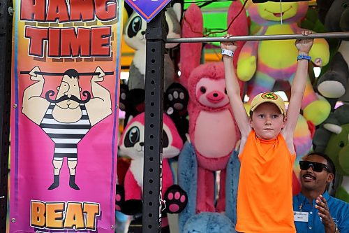 07062023
Seven-year-old Emmett Retzlaff tries to hang on to win the Hang Time game on the midway during the opening night of the 2023 Manitoba Summer Fair at the Keystone Centre on a hot and stormy Wednesday night. (Tim Smith/The Brandon Sun)