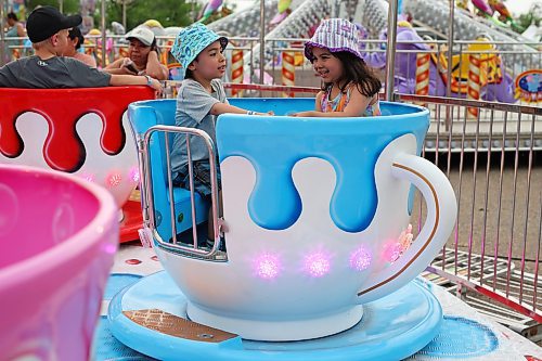 07062023
Esteban Hernandez and Isabella Recinos ride the teacups during the opening night of the 2023 Manitoba Summer Fair at the Keystone Centre on a hot and stormy Wednesday night. (Tim Smith/The Brandon Sun)