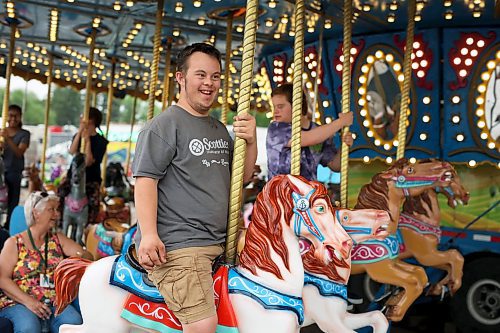 08062023
Daniel Lourenco with &#xc9;cole Secondaire Neelin High School&#x2019;s Life Skills program rides the carousel during Westman Disability Day at the Manitoba Summer Fair on Thursday afternoon. The event provided an opportunity for individuals with physical and/or intellectual disabilities and their families and caregivers to enjoy the fair for free without the usual crowds.
(Tim Smith/The Brandon Sun)