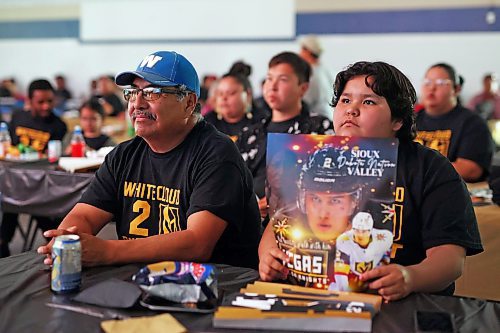 08062023
Karla Bunn holds a poster featuring Las Vegas Golden Knights player Zach Whitecloud of Sioux Valley Dakota Nation while watching game three of the Stanley Cup finals between the Golden Knights and the Florida Panthers with Rollie Bunn at a Stanley Cup viewing party for community members at Sioux Valley on Thursday evening. The event featured a BBQ supper, cake and the game broadcast on two big screens. (Tim Smith/The Brandon Sun)