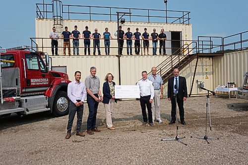 (Front row, left to right) Cenovus Minnedosa Ethanol Plant manager Avi Bahl, vice-president of Canadian Downstream Manufacturing & Technical Service Kerry Margetts, and senior vice-president of Canadian Downstream Manufacturing & Technical Service Doreen Cole present a $155,000 cheque to Minnedosa Fire Chief Dean Jordan, Minnedosa Mayor Ken Cameron and the town's chief administrative officer, James Doppler, as some of Minnedosa's voluntary fire crew looks on from a building at the Minnedosa Fire Training Centre on Friday morning. The funds will be used to purchase a new fire engine and to support the training grounds. (Miranda Leybourne/The Brandon Sun)