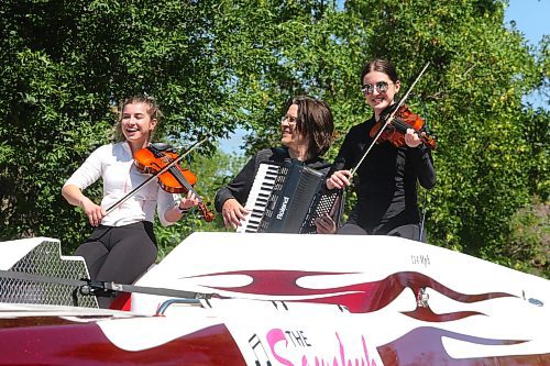 Ukrainian violinists Brenna and Brooklynn Sawchuk perform for the excited Travellers' Day Parade crowd this past weekend with their father Jason accompanying them on the electric accordion. (Kyle Darbyson/The Brandon Sun)