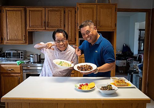 JESSICA LEE / WINNIPEG FREE PRESS

Rod Cantiveros (left) and his son Ron Cantiveros are photographed at Ron&#x2019;s home June 10, 2023 with Pork Belly Adobo and other foods that Rod made.

Reporter: Eva Wasney