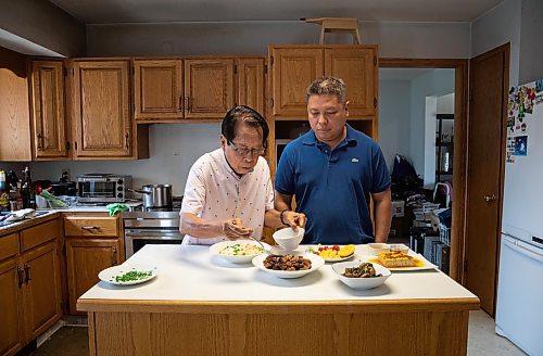 JESSICA LEE / WINNIPEG FREE PRESS

Rod Cantiveros (left) and his son Ron Cantiveros are photographed at Ron&#x2019;s home June 10, 2023 with Pork Belly Adobo and other foods that Rod made.

Reporter: Eva Wasney
