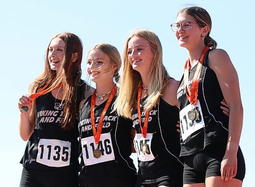 Vincent Massey’s Anne Forman (1135), twins Sydney (1146) and Kendra Schram (1145) and Juliana Crocker (1130) pose with their gold medals after winning the 4x100 relay at Brandon’s UCT Stadium during the Manitoba High School Sports Association’s track and field provincials on Saturday afternoon. (Perry Bergson/The Brandon Sun)