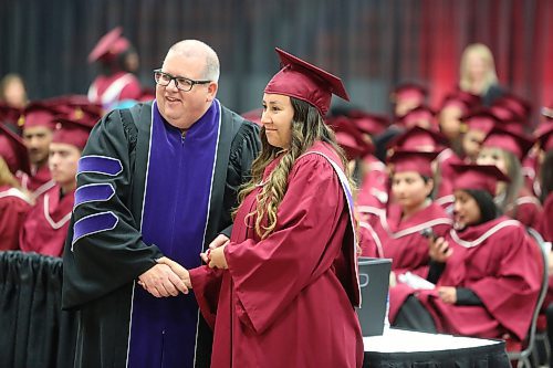 Assiniboine Community College president Mark Frison hands a diploma to medical administration student Alana Muswagon during Friday morning's graduation ceremony in Brandon. (Kyle Darbyson/The Brandon Sun)