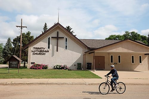 16062023
A woman cycles past the Trinity Lutheran Church in Dauphin on Friday. The church was open as a place for family to congregate on Thursday in the wake of the horrific collision at Carberry that claimed the lives of 15 Dauphin residents and injured 10 others.  (Tim Smith/The Brandon Sun)