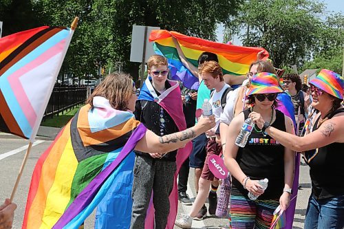 A Brandon Pride volunteer makes sure that the attendees of Saturday's Pride march are well-hydrated as they make their way down Victoria Avenue. (Kyle Darbyson/The Brandon Sun)
