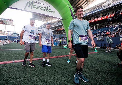 JOHN WOODS / WINNIPEG FREE PRESS
Rick Bochinski,55, with his dad Garry, 81, and son Michael, 25, finish their run together in the 45th Manitoba Marathon in Winnipeg, Sunday, June 18, 2023. 

Reporter: Donald