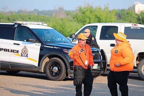 Members of the Brandon Regional Search and Rescue Association converse in the Riverbank Discovery Centre parking lot Saturday evening. The group was called in to help with a search and rescue operation near the facility earlier that afternoon. (Kyle Darbyson/The Brandon Sun) 