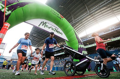 JOHN WOODS / WINNIPEG FREE PRESS
Dana, Sully, and Tim Shantz push a stroller over the finish as other runners take part in the 45th Manitoba Marathon in Winnipeg, Sunday, June 18, 2023. 

Reporter: Donald