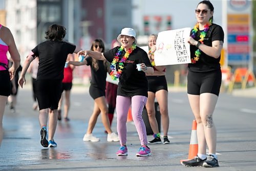 BROOK JONES / WINNIPEG FREE PRESS
Paula Wiebe (middle) is all smiles, while helping out at a volunteer water station run by Altea Active Fitness Club along Pembina Highway at the Manitoba Marathon in Winnipeg, Man., Sunday, June 18, 2023. 