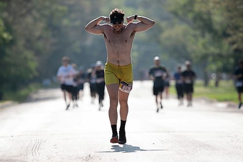 BROOK JONES / WINNIPEG FREE PRESS
Shay Woodrow flexes his pipes as he runs down Crescent Drive, while competing in the half marathon at the Manitoba Marathon in Winnipeg, Man., Sunday, June 18, 2023. 