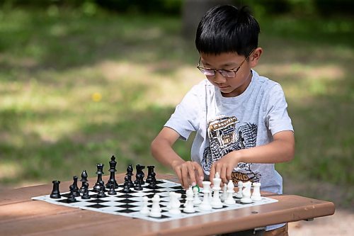 BROOK JONES / WINNIPEG FREE PRESS
Eight-year-old Aiden Ling, who attends Linden Christian School, sets up a chess match, while visiting King's Park with his mother, Joan Wang, on the afternoon of Sunday, June 18, 2023. The Grade 2 student recently placed third in his age category at the Chess'n Math Canadian Chess Challenge in Montreal, Que., in May. He will be competing at the Canadian Youth Chess Challenge in Calgary, Alta., from July 19 to 22. 