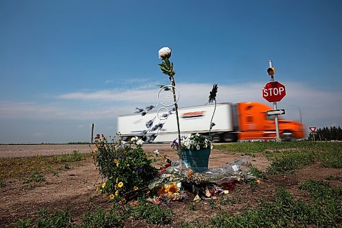 20062023
A semi trailer pass by flowers and other items placed at the intersection of the Trans Canada Highway and Highway 5 just north of Carberry as a memorial to the victims of last weeks devastating collision involving a semi trailer and a passenger bus carrying seniors from Dauphin to the Sand Hills Casino.   (Tim Smith/The Brandon Sun)