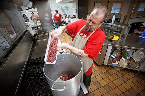 Mike Deal / Winnipeg Free Press
Roger West adds some stewing beef to a large pot in the kitchen at 324 Logan Avenue early Tuesday morning. Employed by Community Helpers Unite, an organization that employs around six to eight people who cook and prepare food and distribute them, for free,  to various organizations such as Main St Project.
230620 - Tuesday, June 20, 2023.