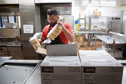 Mike Deal / Winnipeg Free Press
Kashish Kashish unboxes frozen bagels in the kitchen at 324 Logan Avenue early Tuesday morning. Employed by Community Helpers Unite, an organization that employs around six to eight people who cook and prepare food and distribute them, for free,  to various organizations such as Main St Project.
230620 - Tuesday, June 20, 2023.