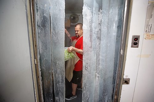 Mike Deal / Winnipeg Free Press
Roger West gets some vegetables from the walk-in refrigerator in the kitchen at 324 Logan Avenue early Tuesday morning. Employed by Community Helpers Unite, an organization that employs around six to eight people who cook and prepare food and distribute them, for free,  to various organizations such as Main St Project.
230620 - Tuesday, June 20, 2023.