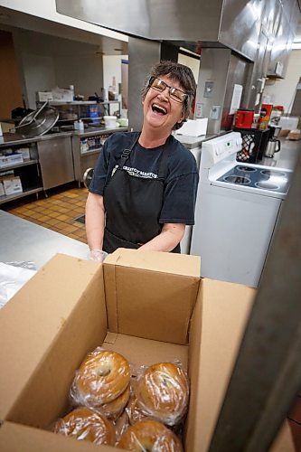 Mike Deal / Winnipeg Free Press
Heather Wade laughs while portioning out bagels in the kitchen at 324 Logan Avenue early Tuesday morning. Employed by Community Helpers Unite, an organization that employs around six to eight people who cook and prepare food and distribute them, for free,  to various organizations such as Main St Project.
230620 - Tuesday, June 20, 2023.