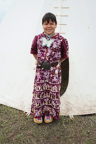 Willow Bogacki, age 9, wore a traditional jingle dress and moccasins to the pow wow held at Rolling River First Nation on Wednesday. (Miranda Leybourne/The Brandon Sun)