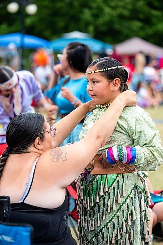 MIKAELA MACKENZIE / WINNIPEG FREE PRESS


Cathy Bird helps Anna Bird (10) get her jingle dress regalia on for the Pow Wow on National Indigenous Peoples Day at The Forks on Wednesday, June 21, 2023.  For Cierra Bettens story.
Winnipeg Free Press 2023