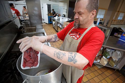 Mike Deal / Winnipeg Free Press
Roger West adds some stewing beef to a large pot in the kitchen at 324 Logan Avenue early Tuesday morning. Employed by Community Helpers Unite, an organization that employs around six to eight people who cook and prepare food and distribute them, for free,  to various organizations such as Main St Project.
230620 - Tuesday, June 20, 2023.