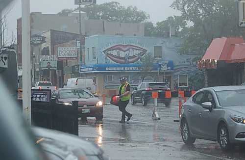 Mike Thiessen / Winnipeg Free Press 
Heavy rain this morning didn&#x2019;t stop some road crews from continuing construction. A contractor directs traffic on Osborne Street. 230622 &#x2013; Thursday, June 22, 2023